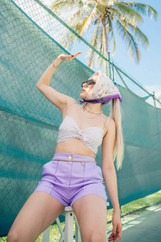 a woman standing on a tennis court holding a racquet, an album cover, trending on pexels, aestheticism, purple halter top, ava max, wearing sunglasses and a cap, hawaii