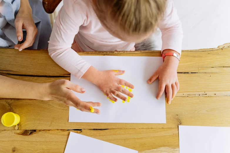 a couple of people that are sitting at a table, a child's drawing, by Arabella Rankin, pexels contest winner, painted nails, white and yellow scheme, press shot, paper craft