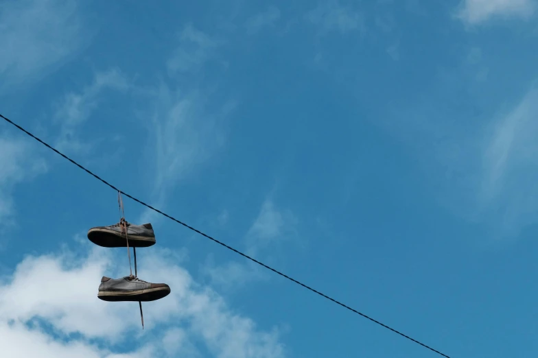 a pair of shoes hanging from a power line, unsplash, postminimalism, sky blue, slide show, portrait photo, concert