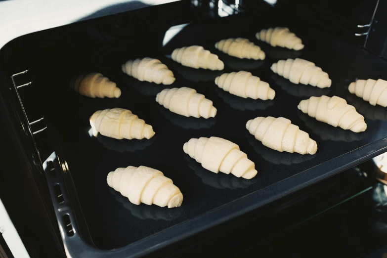 a pan filled with croissants sitting inside of an oven, inspired by Richmond Barthé, alien capsules, press shot, soft pads, spike shell