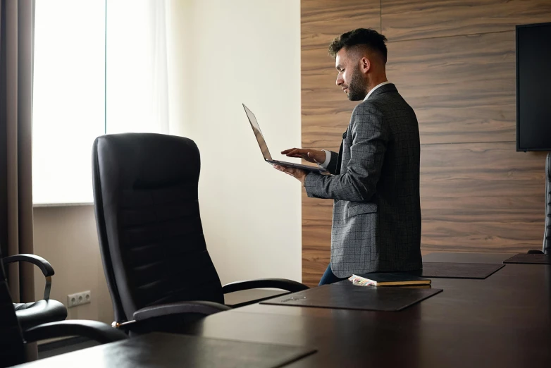 a man in a suit is using a laptop, pexels, figuration libre, standing on a desk, from back, profile image, bendover posture