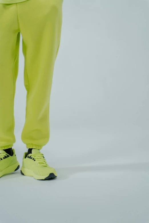 a man in a white shirt and yellow pants, a cartoon, trending on pexels, acid-green sneakers, wearing a tracksuit, photographed for reuters, high-body detail