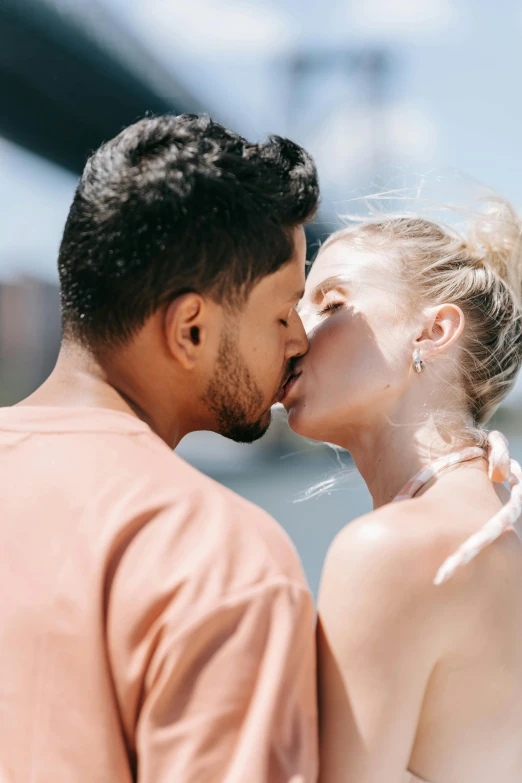 a man and a woman kissing in front of a bridge, trending on pexels, manly, bright sunny day, spiky, diverse