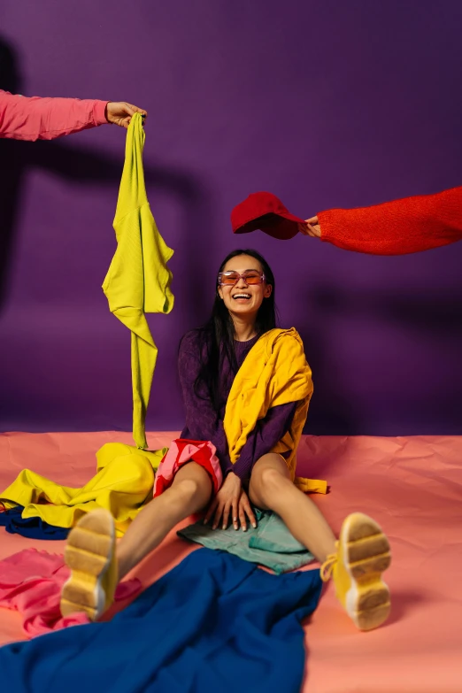 a group of people sitting on top of a bed, inspired by Ren Hang, pexels contest winner, color field, purple outfit, girl wearing round glasses, smiling playfully, primary colors