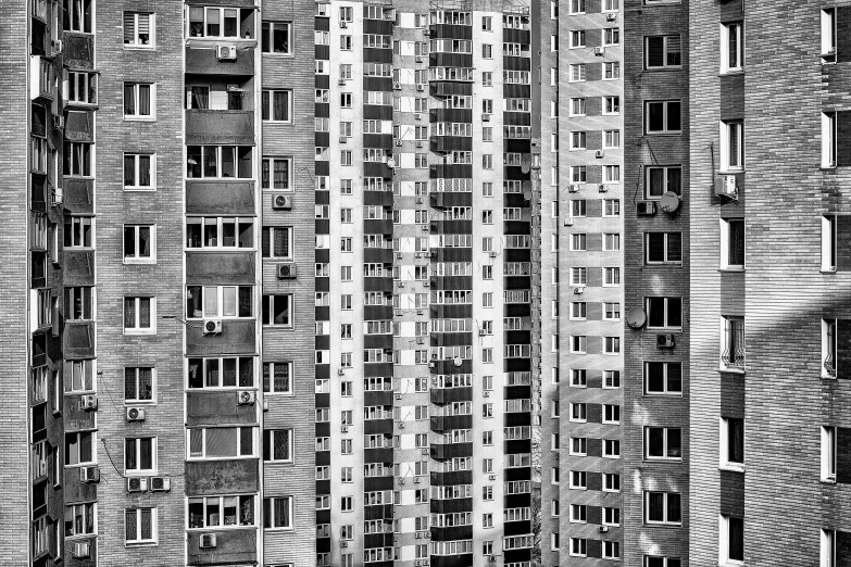 a black and white photo of a tall building, a black and white photo, by Ihor Podolchak, windows and walls :5, an overpopulated, azamat khairov, shot on 1 5 0 mm