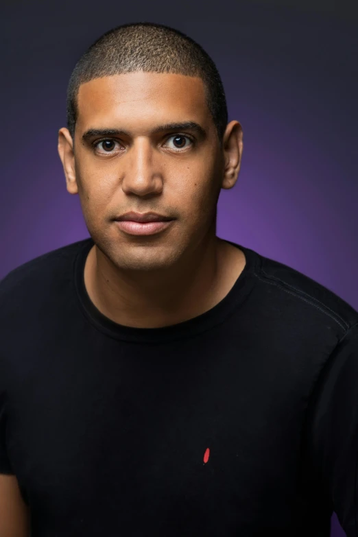a man in a black shirt posing for a picture, a character portrait, inspired by Carlos Berlanga, unsplash, black purple studio background, clean shaven, taken in the late 2010s, philip coles
