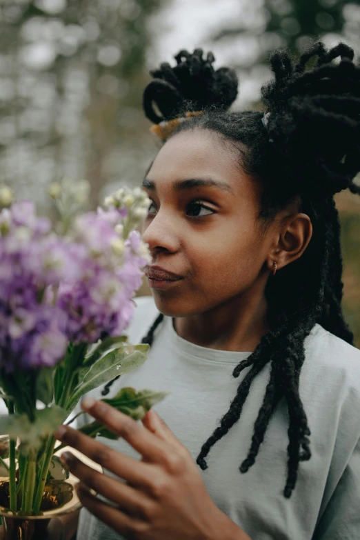 a woman with dreadlocks holding a potted plant, pexels contest winner, purple flowers, black teenage girl, large)}], flirting