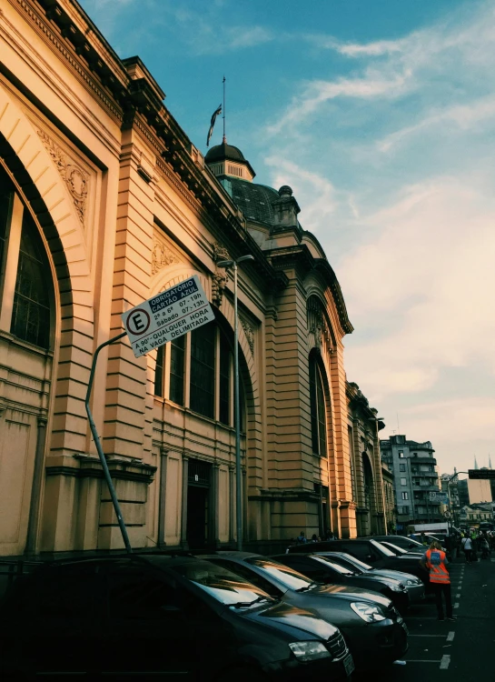 a row of parked cars in front of a building, by Alexander Runciman, pexels contest winner, quito school, train station in summer, instagram story, golden hour scene, cairo