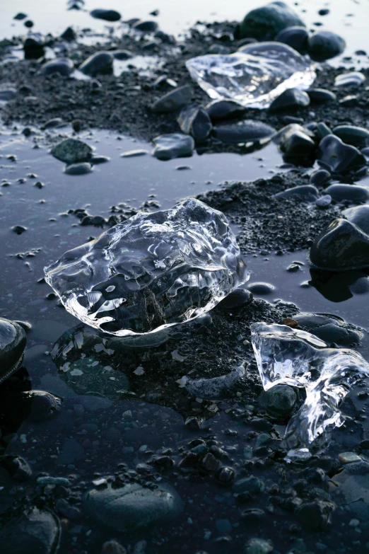 a bunch of ice sitting on top of a puddle of water, “diamonds, rocky beach, environments ), ignant