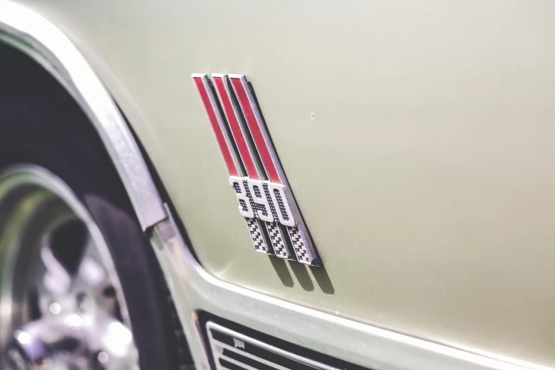 a close up of the emblem on a car, a colorized photo, by Daniel Lieske, unsplash, muscle cars, thin red lines, 🚿🗝📝, triple six