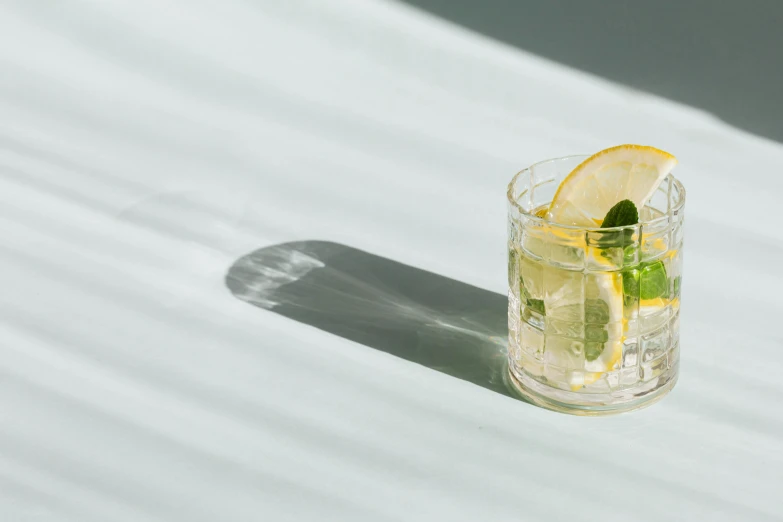 a glass of lemonade with a slice of lemon, unsplash, mies van der rohe, multiple stories, background image, mint