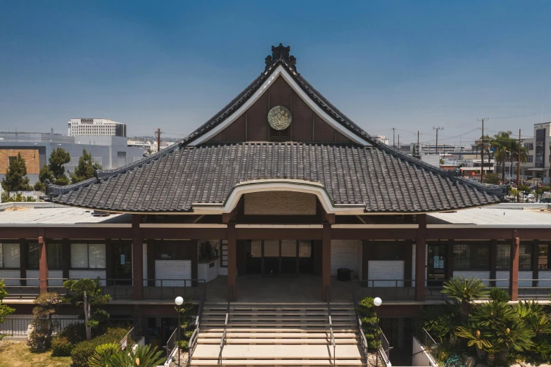 a large building with a clock on top of it, inspired by Tōshi Yoshida, unsplash, sōsaku hanga, oceanside, roof with vegetation, museum photo, frontal view