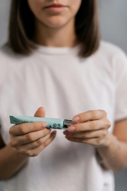 a woman holding a toothbrush in her hands, by Adam Marczyński, pexels contest winner, product label, zoomed view of a banknote, soft volume absorbation, diecut