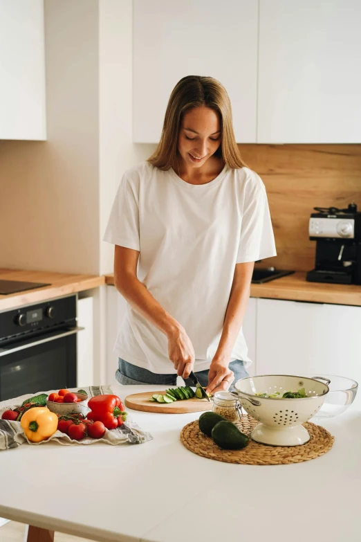 a woman standing in a kitchen preparing a meal, pexels contest winner, white shirt and jeans, australian, veggies, profile image