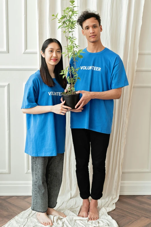 a couple of people standing next to a plant, blue tight tshirt, official product photo, 王琛, # nofilter