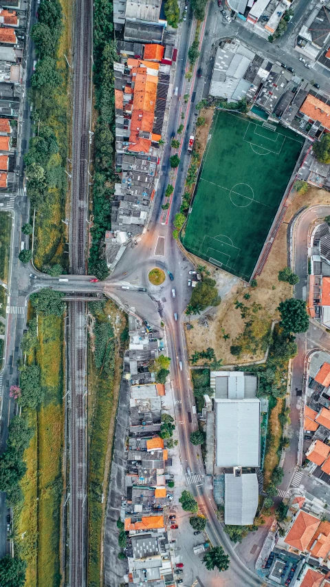 an aerial view of a soccer field in a city, an album cover, by Nadir Afonso, pexels contest winner, overpass, houses and roads, gui guimaraes, thumbnail