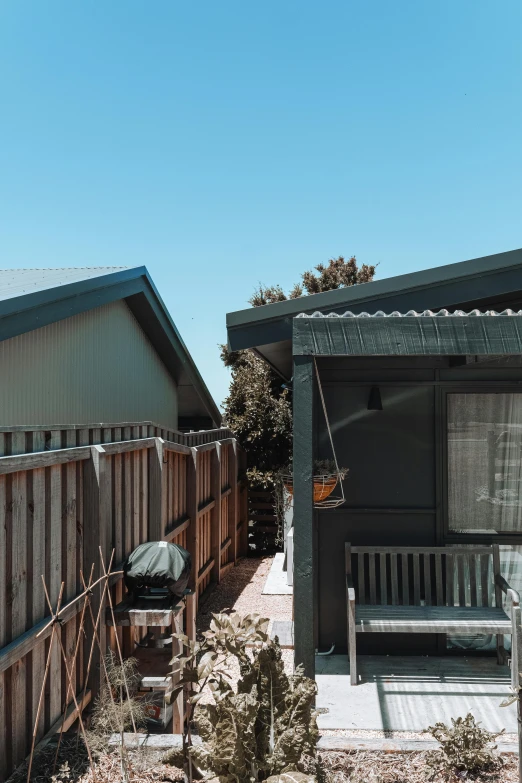 a couple of houses sitting next to each other, an album cover, unsplash, photorealism, manuka, back yard, shed roof, low quality photo