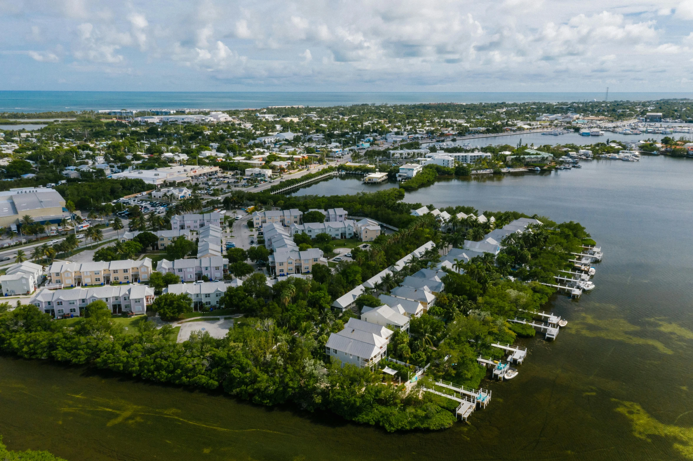 a small island in the middle of a body of water, white houses, florida, high res 8k, fan favorite