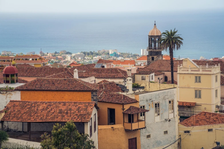 a view of a town with the ocean in the background, by Daniel Lieske, pexels contest winner, renaissance, square, tiled roofs, sunfaded, conde nast traveler photo