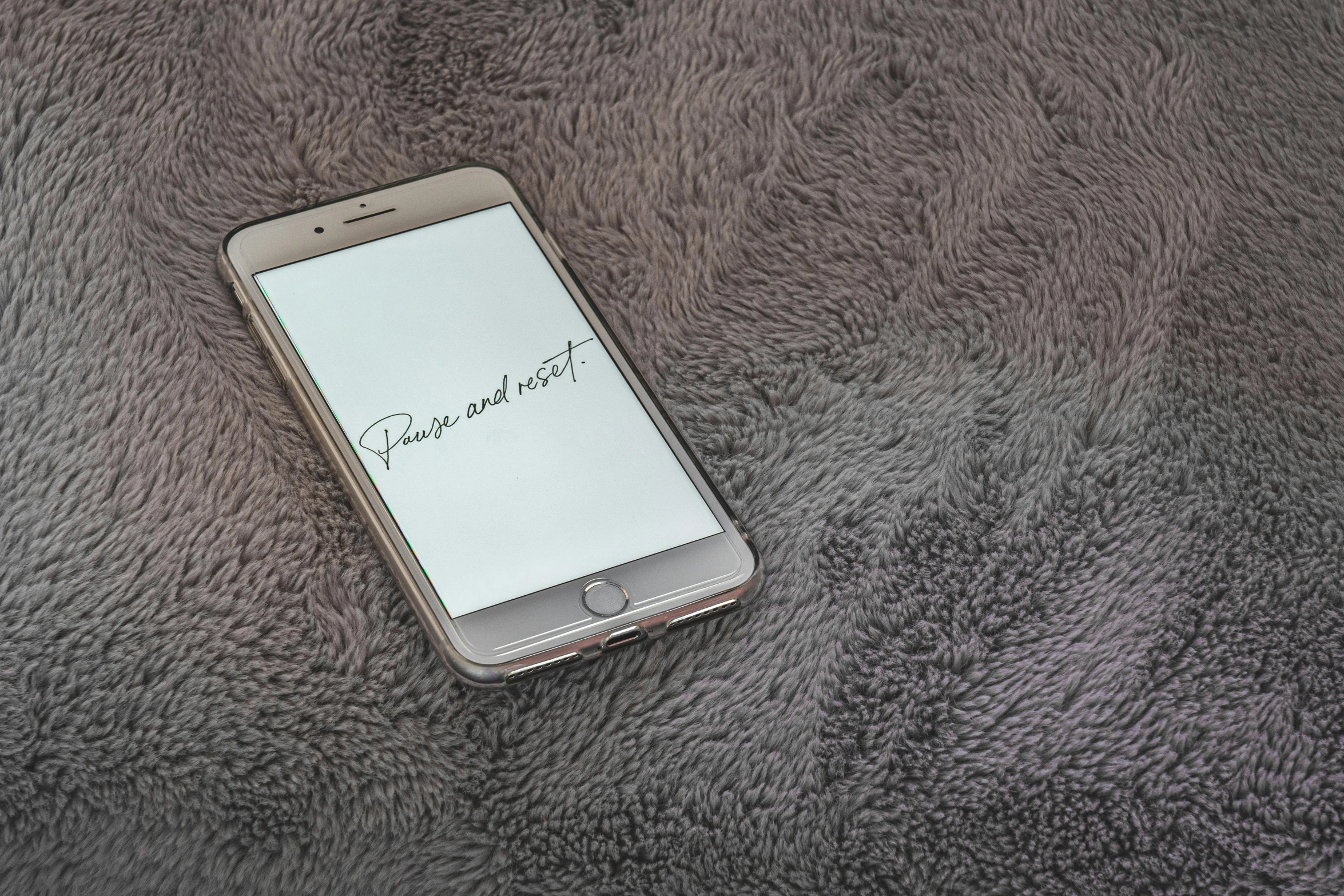 a close up of a cell phone on a furry surface, by Robbie Trevino, pexels, realism, “modern calligraphy art, cozy wallpaper, grey, peace and quiet