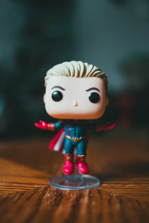 a close up of a toy on a table, by Ryan Pancoast, pexels, elon musk funko pop, captain marvel, blond boy, lgbtq