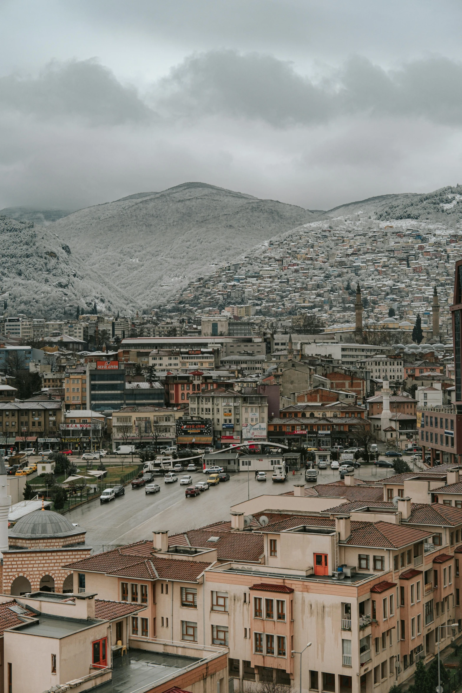 a view of a city with mountains in the background, a colorized photo, inspired by Peter Zumthor, trending on unsplash, renaissance, ground covered with snow, bosnian, square, turkey