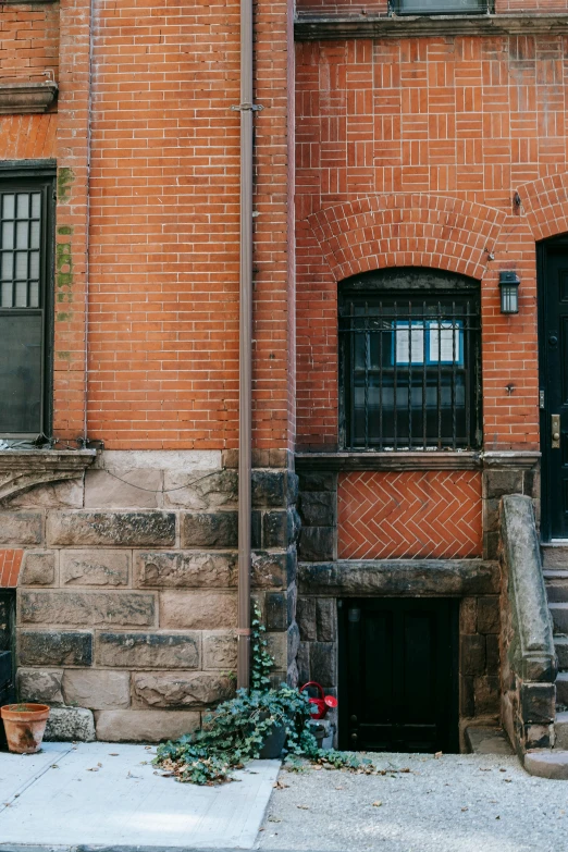 a red fire hydrant sitting on the side of a brick building, a photo, by Nina Hamnett, pexels contest winner, modernism, arched doorway, a cozy old victorian loft, panoramic shot, black windows