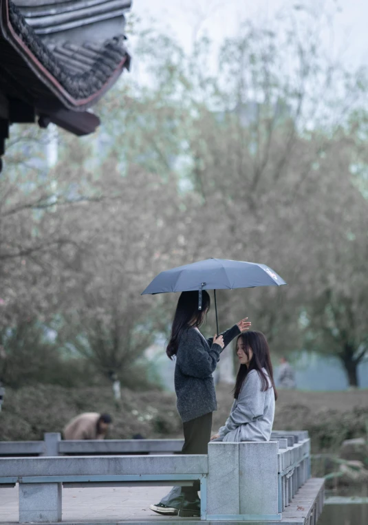 a woman sitting on a bench holding an umbrella, a picture, by Fan Qi, unsplash contest winner, realism, man proposing his girlfriend, in a movie still cinematic, hangzhou, grey