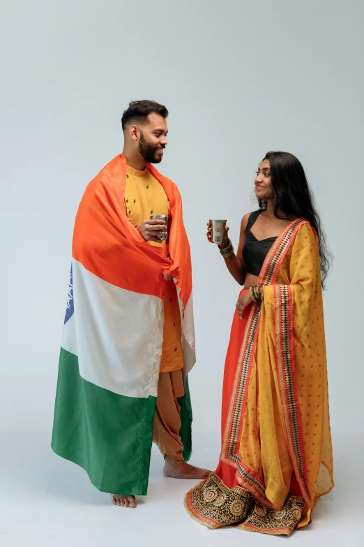 a man and a woman standing next to each other, trending on reddit, indian flag, celebration of coffee products, covered with blanket, ( ( theatrical ) )