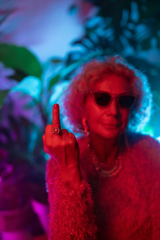 a woman in a fur coat holding up a peace sign, pexels, maximalism, cinematic neon uplighting, older woman, wearing shades, ganja