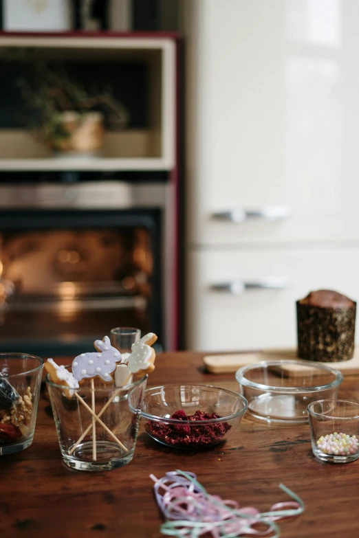 a wooden table topped with dishes of food, by Elizabeth Durack, unsplash, process art, fireplace, candy treatments, glassware, brown