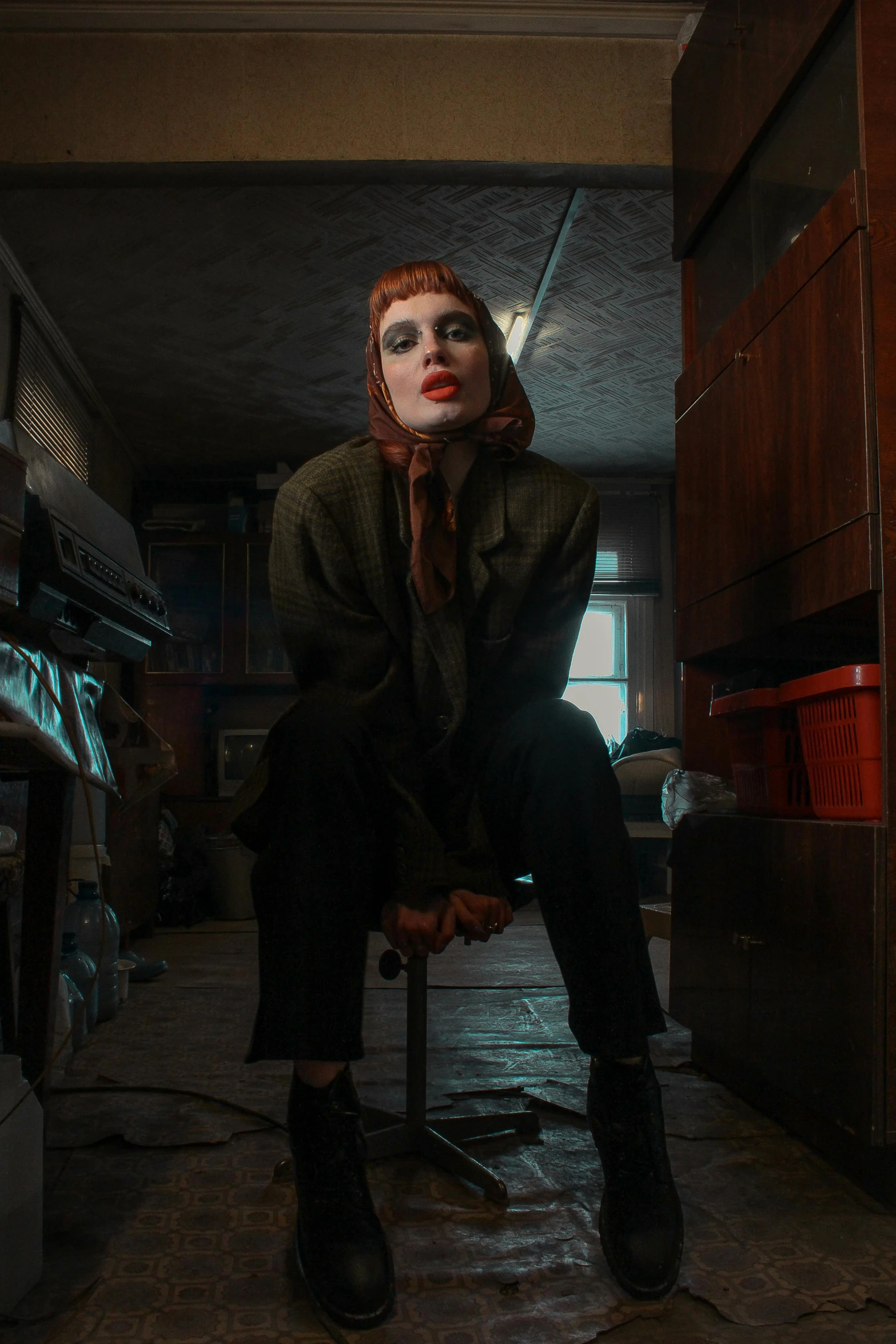 a woman sitting on top of a chair in a kitchen, a portrait, inspired by Elsa Bleda, trending on pexels, lowbrow, redhead female cyberpunk, 4 k cinematic photo, location [ chicago ( alley ) ], pennywise style