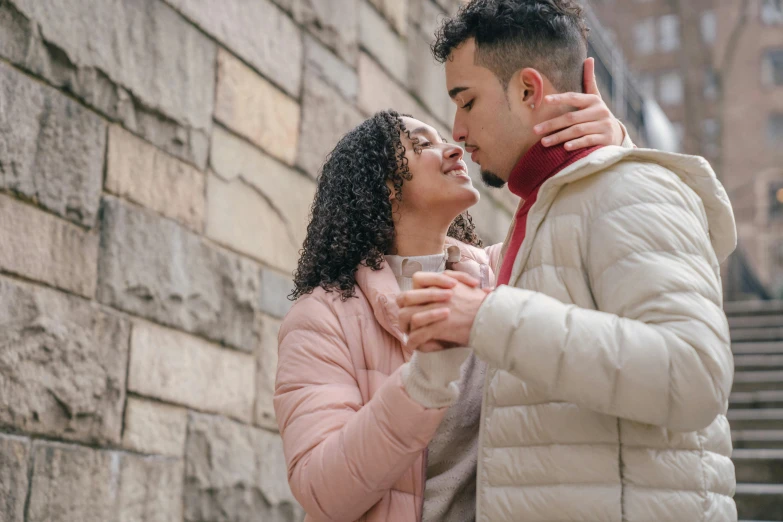 a man and a woman standing next to each other, trending on pexels, renaissance, kissing smile, background image, mixed race, cozy