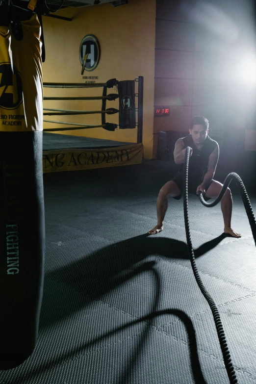 a man working out with a rope in a gym, a portrait, pexels contest winner, process art, black and yellow, mma, square, anaconda