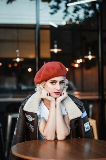 a woman sitting at a table wearing a red beret, inspired by Elsa Bleda, trending on pexels, shoulder pads, square, perfect white haired girl, 🎀 🧟 🍓 🧚