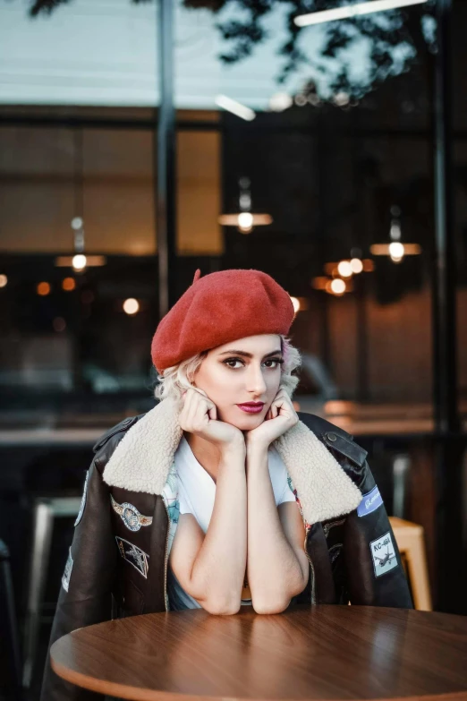 a woman sitting at a table wearing a red beret, inspired by Elsa Bleda, trending on pexels, shoulder pads, square, perfect white haired girl, 🎀 🧟 🍓 🧚