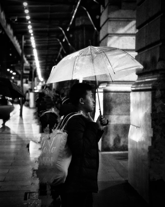 a black and white photo of a woman holding an umbrella, inspired by Vivian Maier, unsplash contest winner, taken in the night, waiting, slightly pixelated, in line