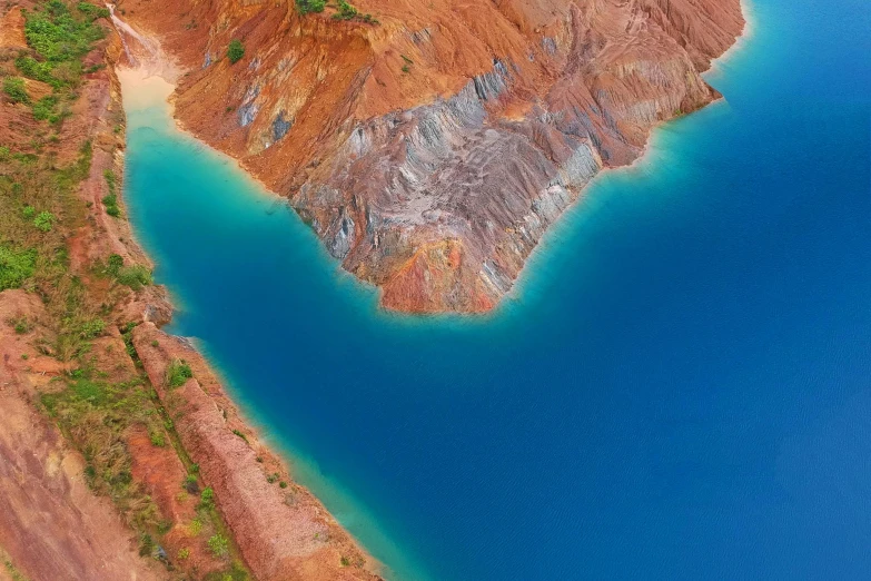 an aerial view of a large body of water, by Julian Allen, pexels contest winner, mining outpost, blue and green and red tones, derealisation, structural geology