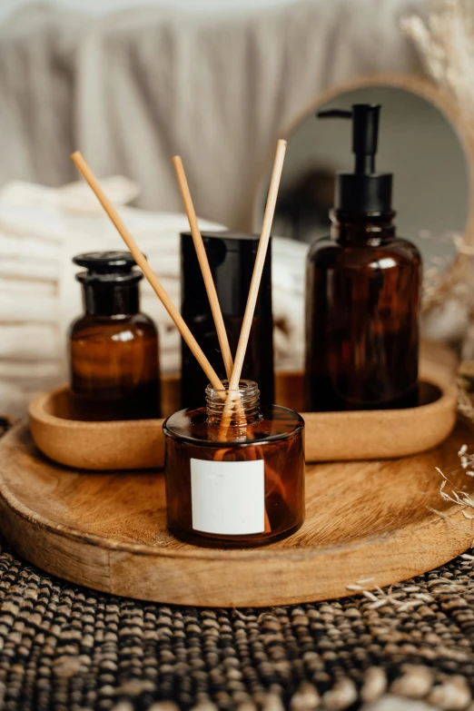 a wooden tray topped with bottles and reeds, unsplash, soap, ambient amber light, easy to use, vapor