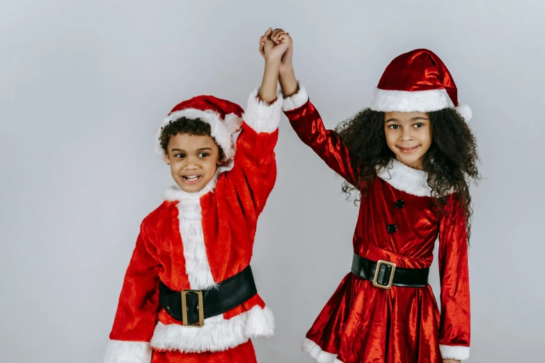 two children dressed up as santa claus and mrs claus, a photo, pexels, incoherents, hands in the air, an olive skinned, gif, ilustration