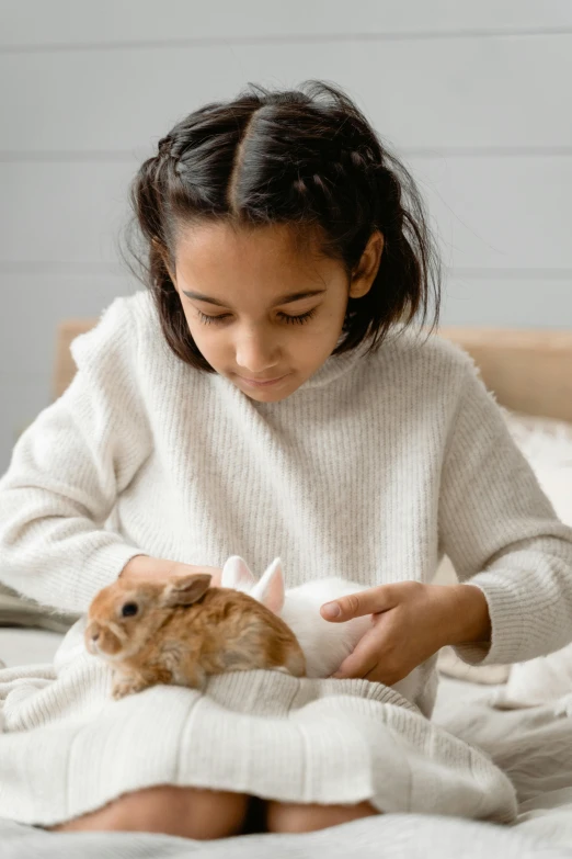 a little girl sitting on a bed feeding a hamster, inspired by Beatrix Potter, pexels contest winner, renaissance, rabbit_bunny, handsome girl, close together, closeup of an adorable