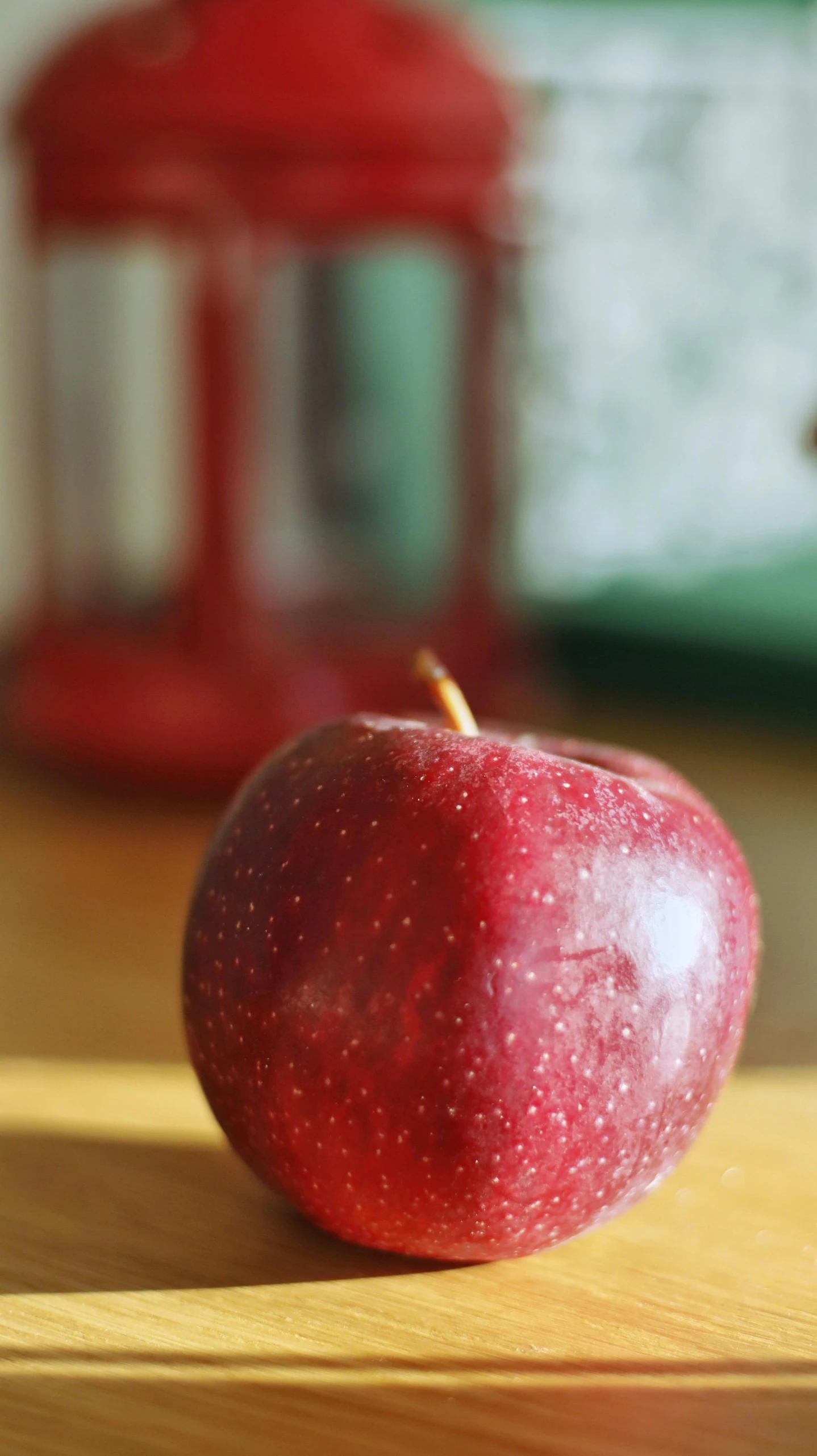 a red apple sitting on top of a wooden table, a still life, by David Donaldson, pexels, schools, no cropping, student, indoor shot