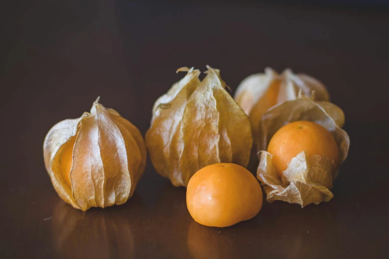 a bunch of fruit sitting on top of a wooden table, by Tom Bonson, unsplash, chinese lanterns, yellowed with age, medium closeup, 6 pack