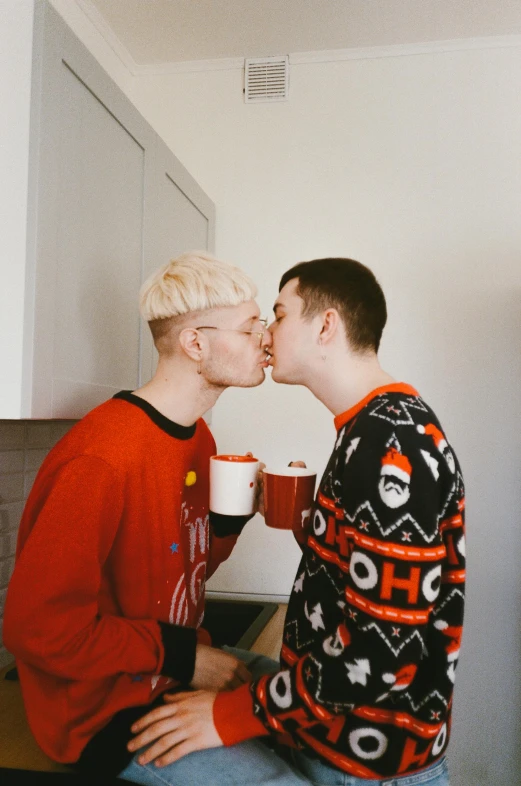 a couple of men sitting on top of a kitchen counter, by Cosmo Alexander, trending on unsplash, wearing festive clothing, lesbian kiss, albino hair, bowl haircut
