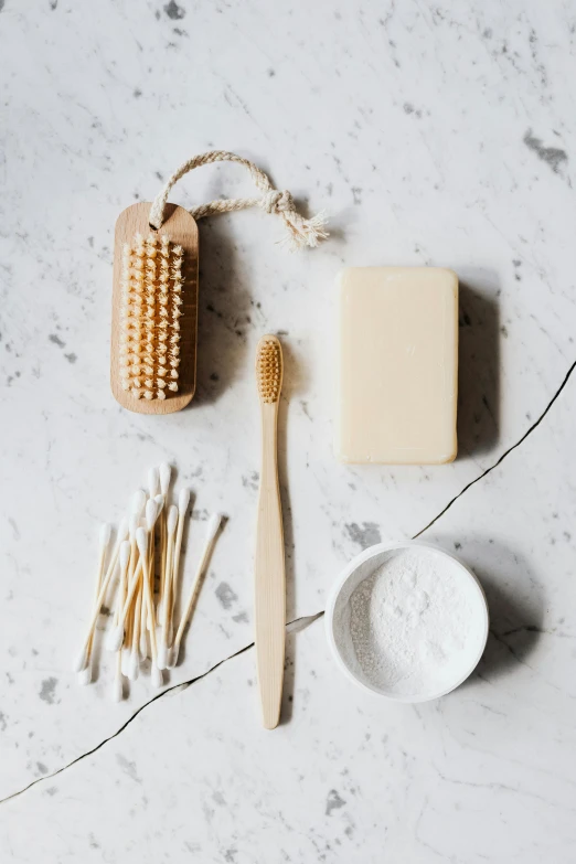 a toothbrush, toothpaste, and toothpaste on a table, a still life, by Daniel Gelon, unsplash, renaissance, made of bamboo, dry brush wash, carved soap, hands on counter