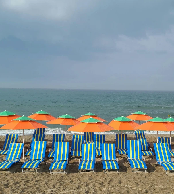 a bunch of beach chairs and umbrellas on a beach, renaissance, fibbonacci, blue and orange, black sea, green