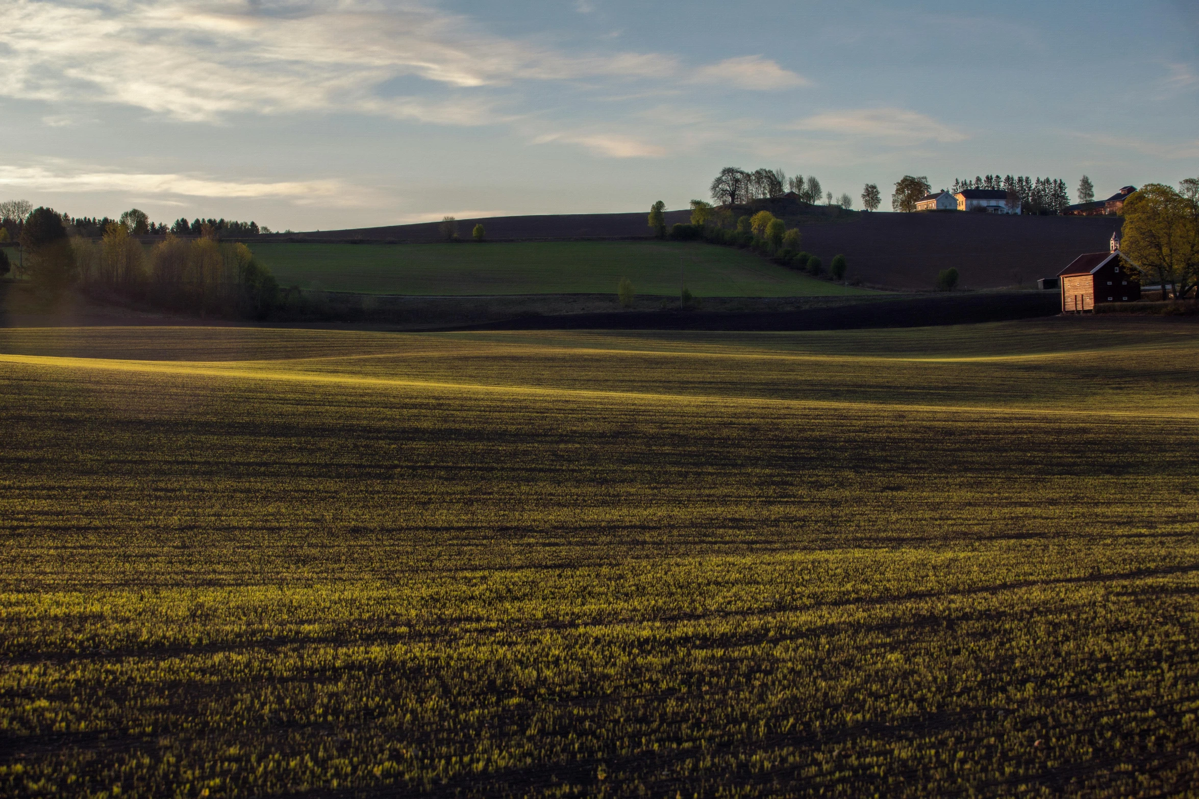 a field with a barn in the distance, by Tobias Stimmer, pexels contest winner, panorama distant view, late afternoon light, cinematic shot ar 9:16 -n 6 -g, hillside