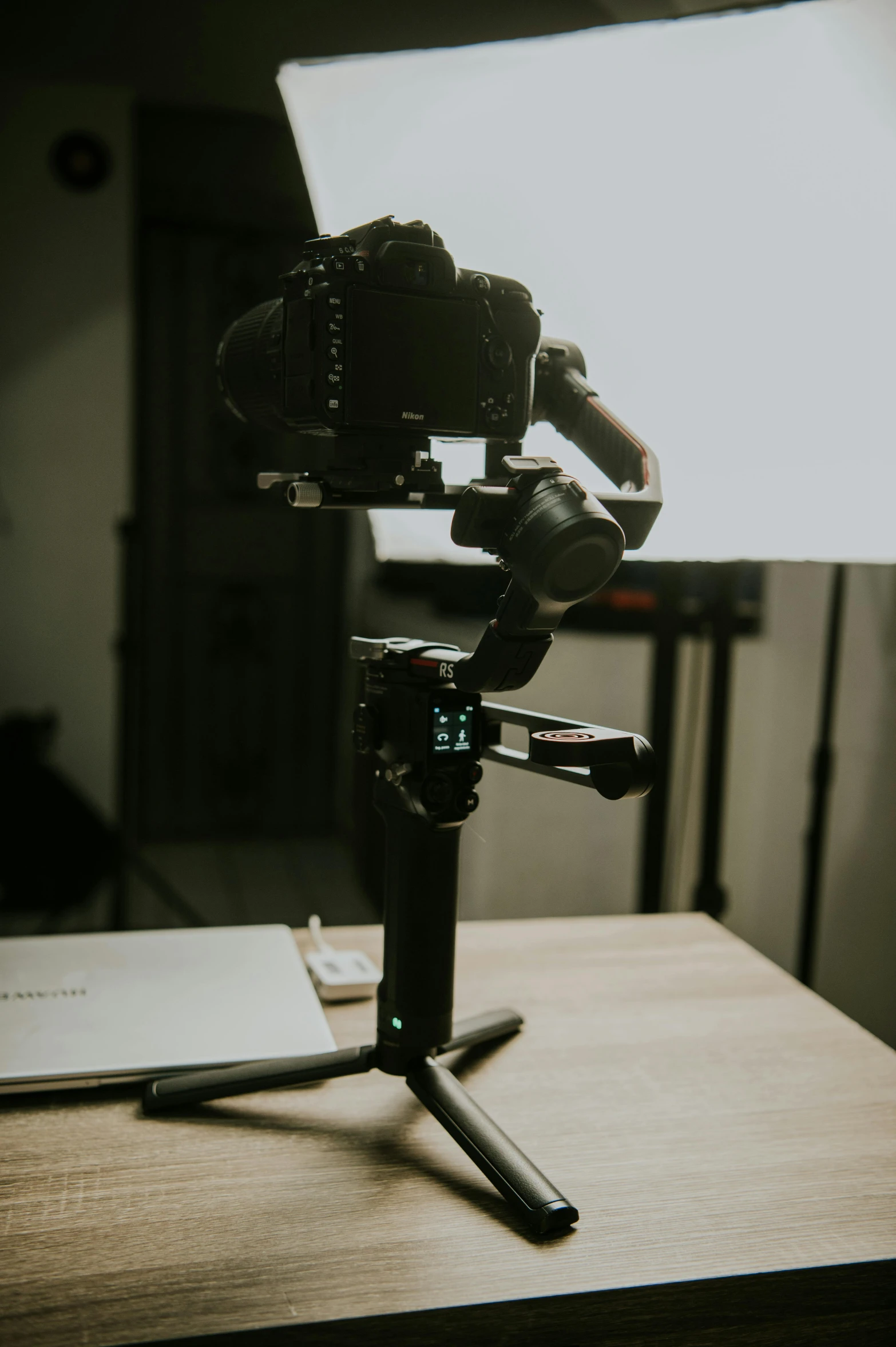 a laptop computer sitting on top of a wooden table, by Andries Stock, pexels contest winner, holography, red camera, robotic arm, cinematic outfit photo, flying towards the camera
