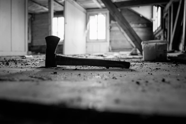 a hammer that is laying on the ground, a black and white photo, by Kristian Zahrtmann, unsplash, conceptual art, in an attic, inside the building, axes, former