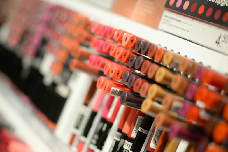 a close up of lipstick on display in a store, pink and orange, paint tubes, sharpie, youthful colours